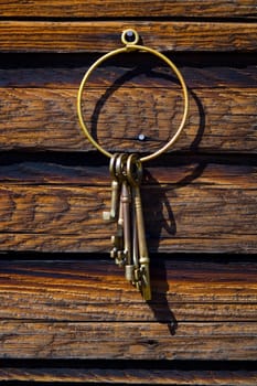 Old-fashioned keys hanging on log wall