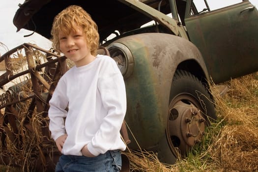 Child beside a rusted vehicle