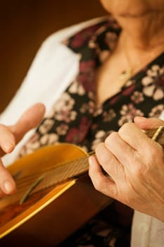 Elderly woman playing a mandolin