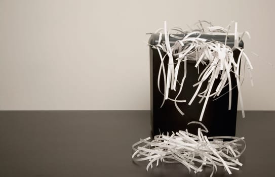 Overflowing garbage can with shredded paper