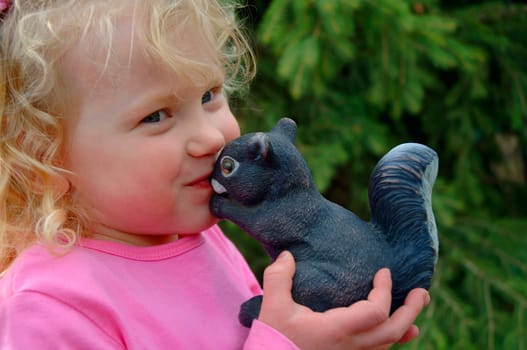 Young girl kissing a squirrel ornament