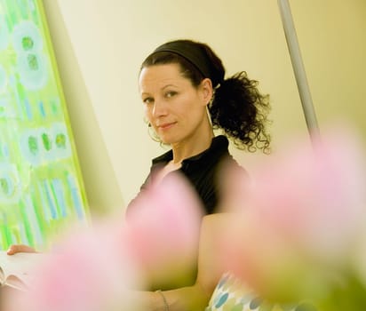 Woman behind blurred flowers