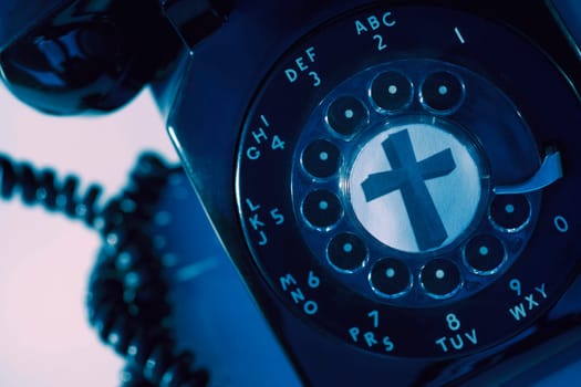 A rotary phone with a cross