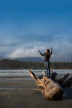 Woman with raised hands on the beach