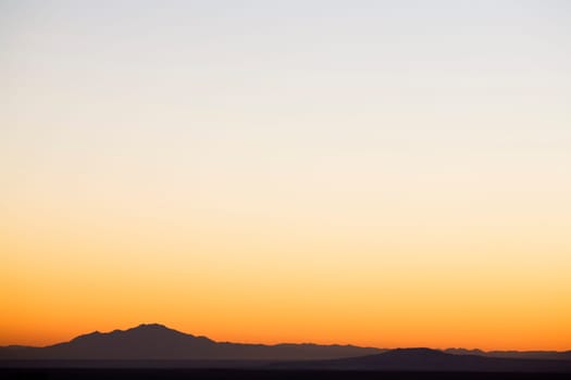Sunset sky over silhouetted mountains