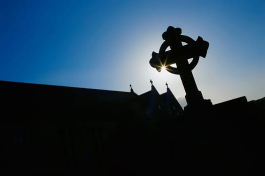 Silhouetted Celtic cross and church