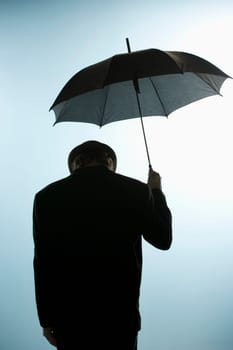 Person with head down holding umbrella