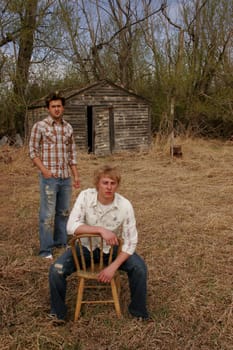 Man sitting in chair and man standing in yard