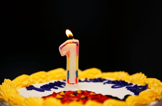 A birthday cake with lit candle