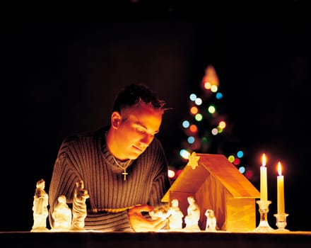 Man with nativity scene figurines and lights