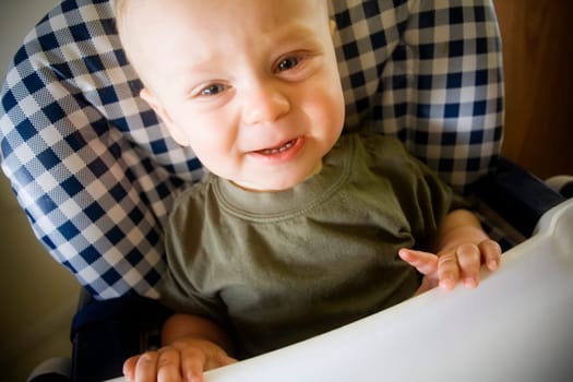 Baby boy crying in highchair
