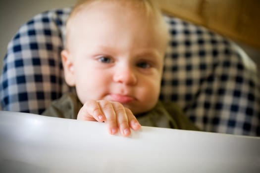 Baby boy pouting in highchair