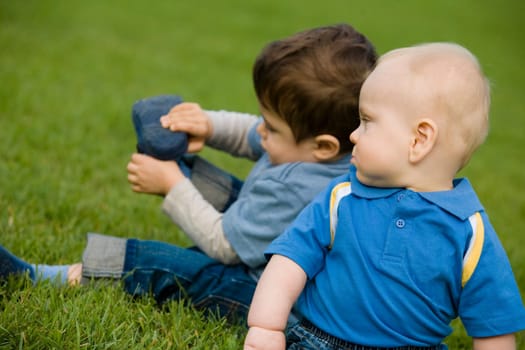 Two boys sitting on grass