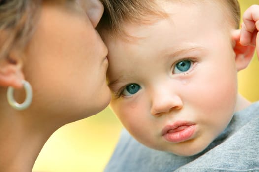 Mother kissing child