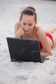 Woman using laptop on the beach