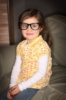 A girl wearing glasses, crossing her eyes