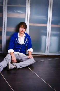Portrait Of A Teenage Boy Sitting On The Ground