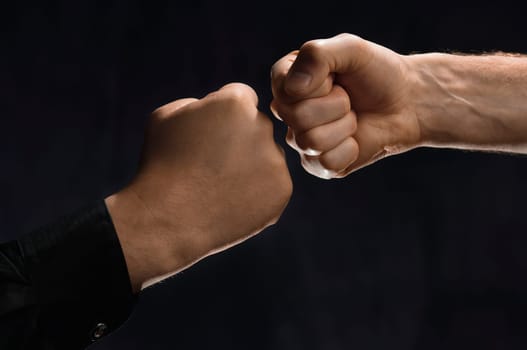 Two men knocking fists together