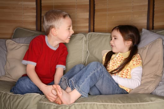 Boy and girl playing on a couch
