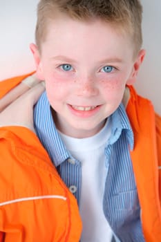Young boy with freckles smiling at camera