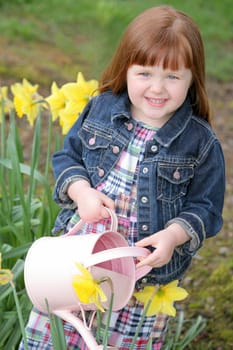Little girl watering flowers
