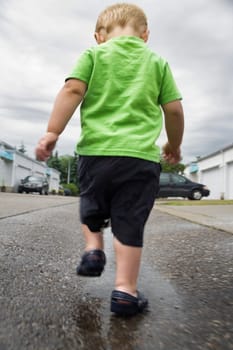 Boy walking in a puddle