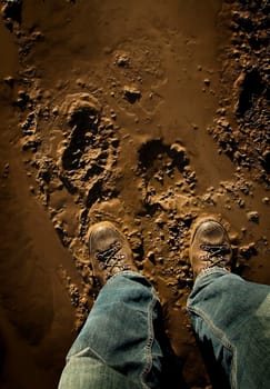 Low section of person standing in mud