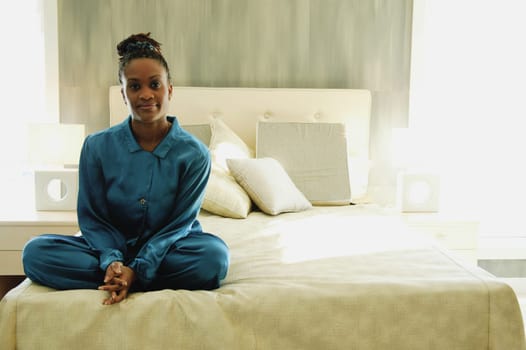 Woman sits cross-legged on a bed