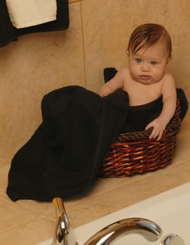 Baby sits in bathroom basket