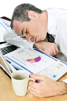 Businessman asleep at his desk on white