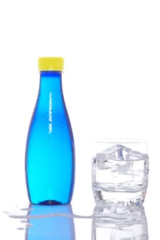 Bottle and glass of mineral water with droplets