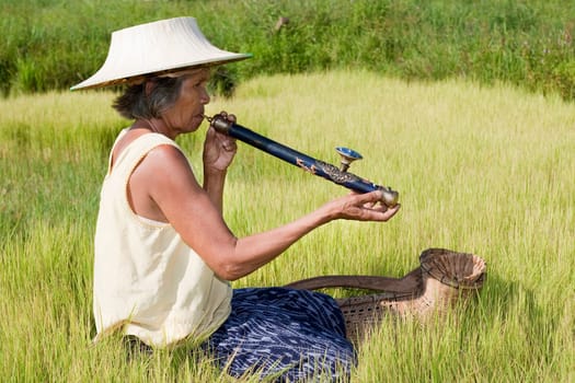 old asian woman with opium pipe