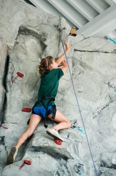 young teen girl rock climbing