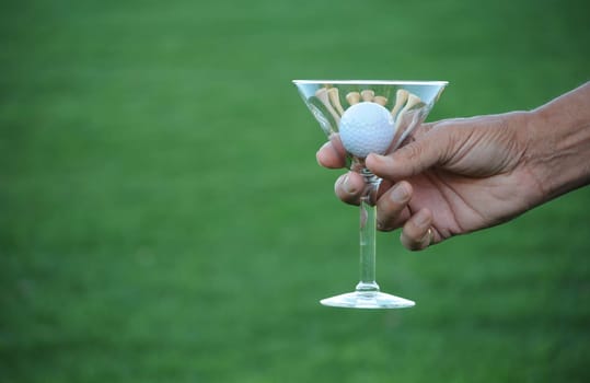 golf ball and tees in martini glass