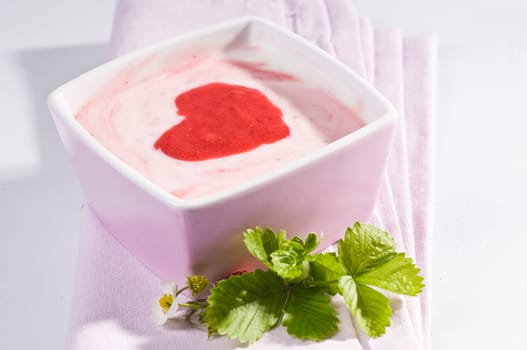 Strawberry curd in pink bowl with red heart made of strawberry sauce