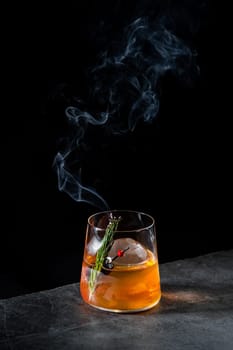 aromatic cocktail with a sprig of pine needles and round ice