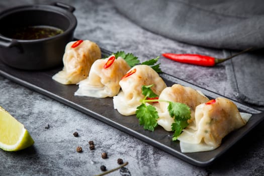 Asian dumplings with soy sauce, chili peppers and herbs