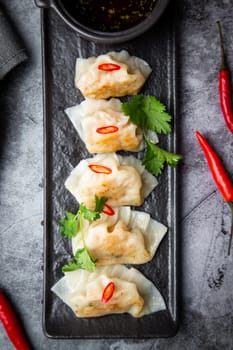 Asian dumplings with soy sauce, chili peppers and herbs