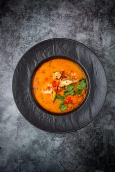 tom yam soup with chicken, lime, cherry tomatoes and parsley