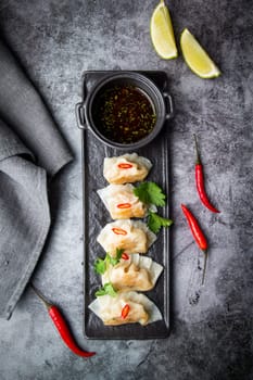 Asian dumplings with soy sauce, chili peppers and herbs