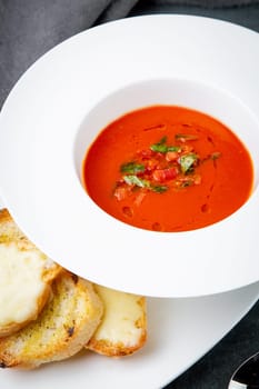 red tomato cream soup with herbs and toasted bread