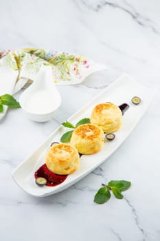 lush and tall cheesecakes with jam and mint on a white plate