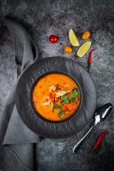 tom yam soup with chicken, lime, cherry tomatoes and parsley