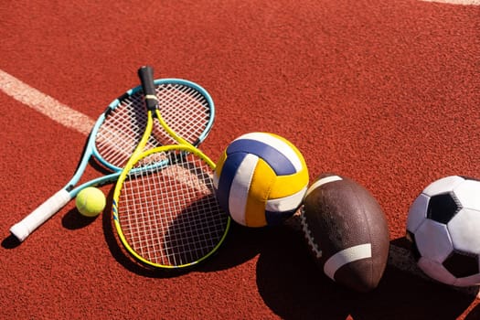 Set of sport equipment, rackets and tennis balls soccer and basketball balls.