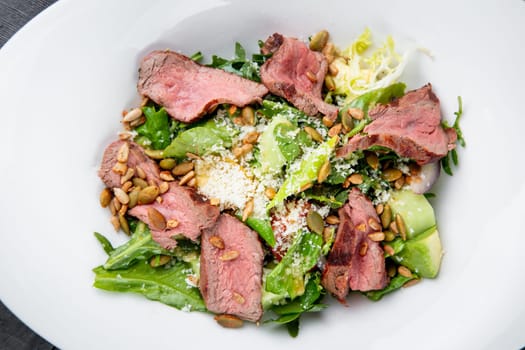 salad with pieces of beef, pistachios, lettuce and cheese. High quality photo