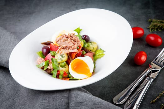 salad with soft-boiled egg, tuna, green onions, boiled potatoes