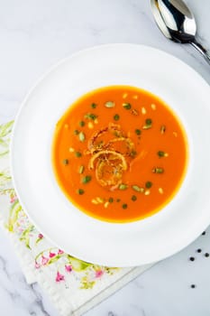 side view of pumpkin cream soup with pieces of meat