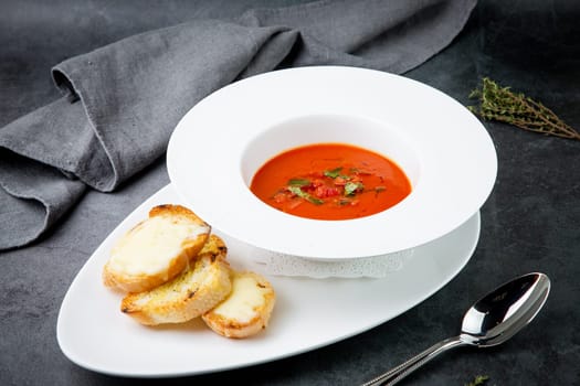 red tomato cream soup with herbs and toasted bread