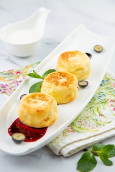 lush and tall cheesecakes with jam and mint on a white plate