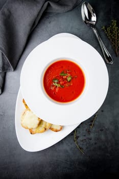 red tomato cream soup with herbs and toasted bread